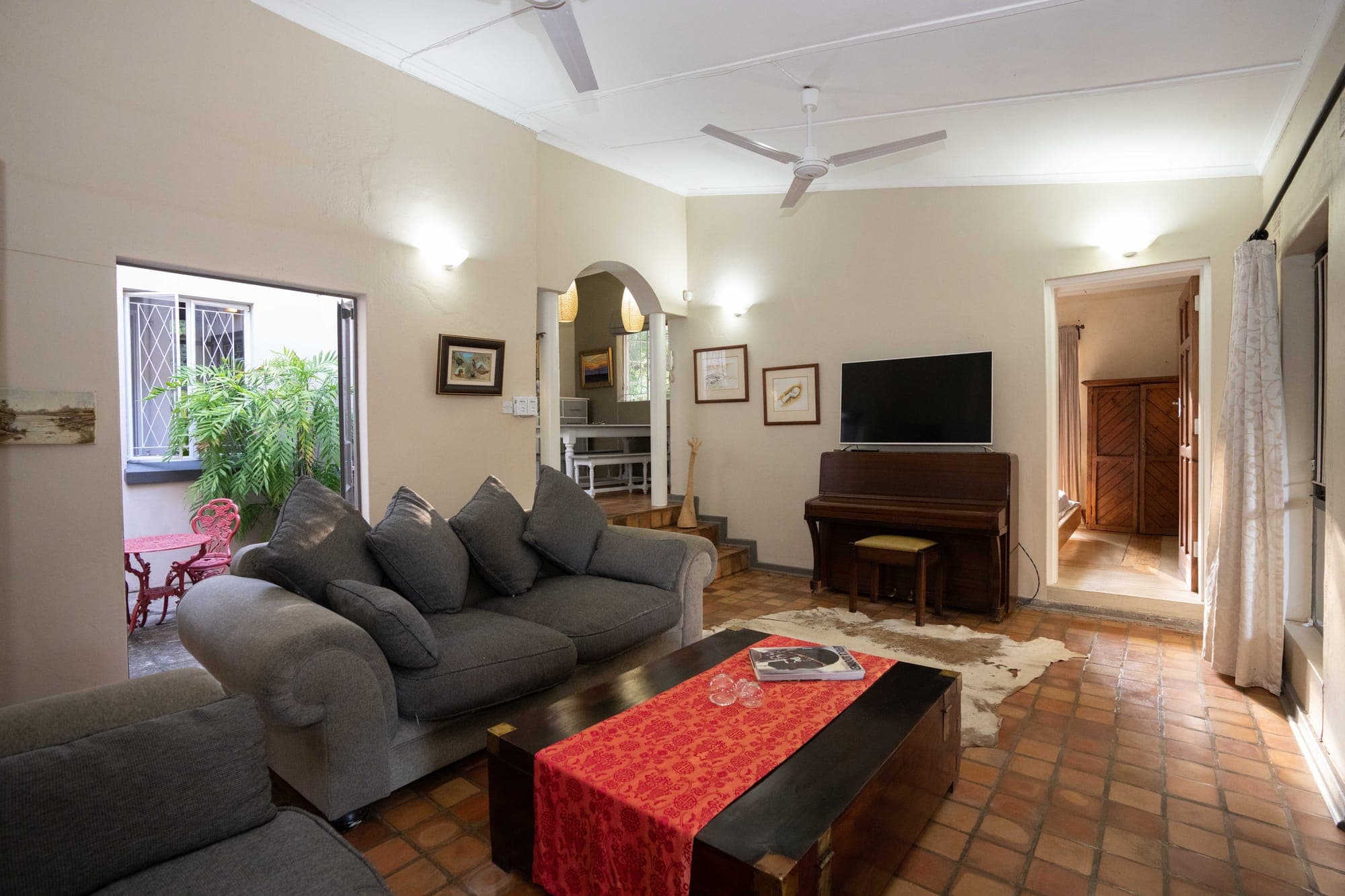 Lounge with sofas, piano and African art at The Art House